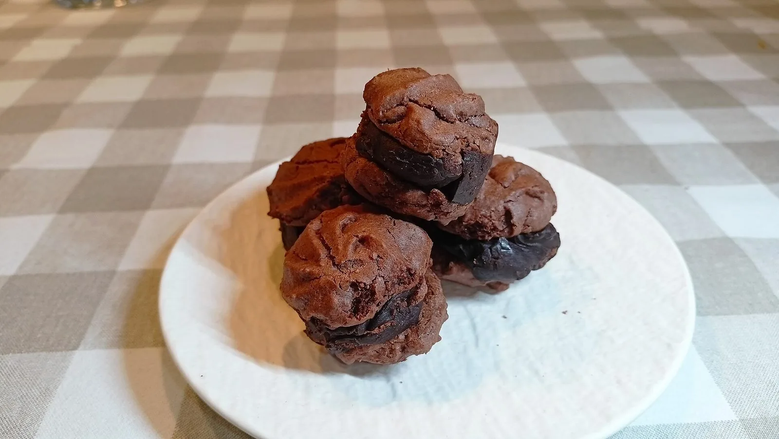 Baci di Alassio al cioccolato con crema scura, su un piattino bianco