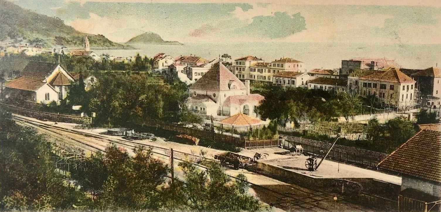 Cartolina d'epoca con la Biblioteca degli Inglesi di Alassio accanto alla ferrovia, con l'isola Gallinara sullo sfondo
