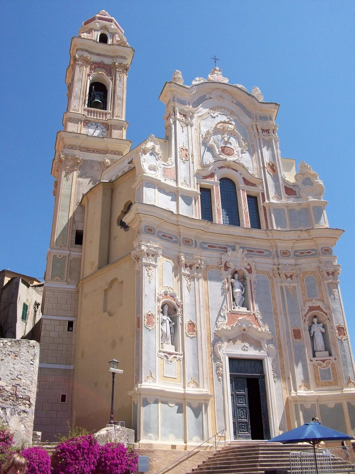 Facciata barocca e campanile della chiesa dei Corallini a Cervo, sotto un cielo azzurro