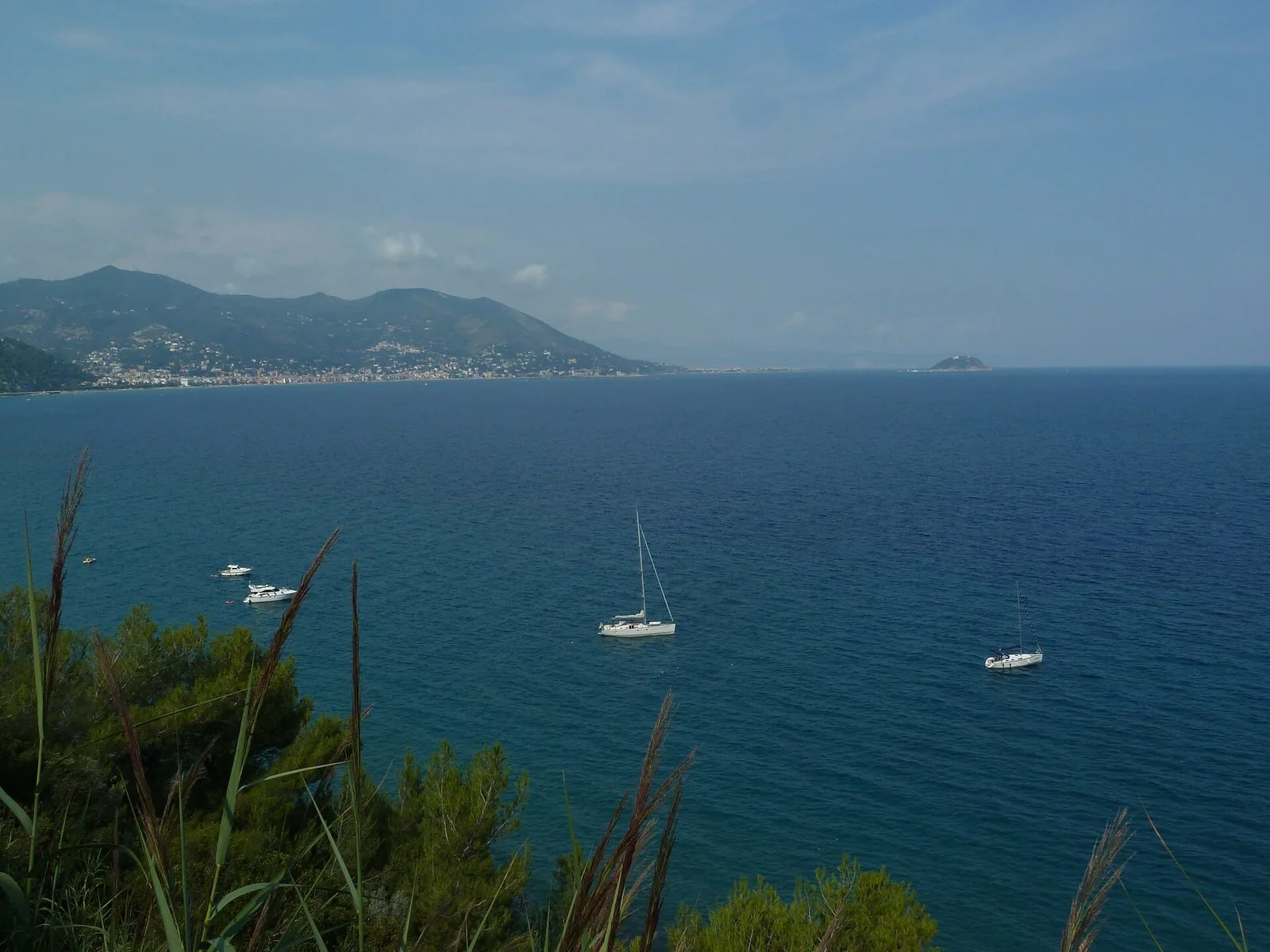 Il golfo di Alassio visto dall'alto da Capo Mele, con barche a vela e l'isola Gallinara all'orizzonte