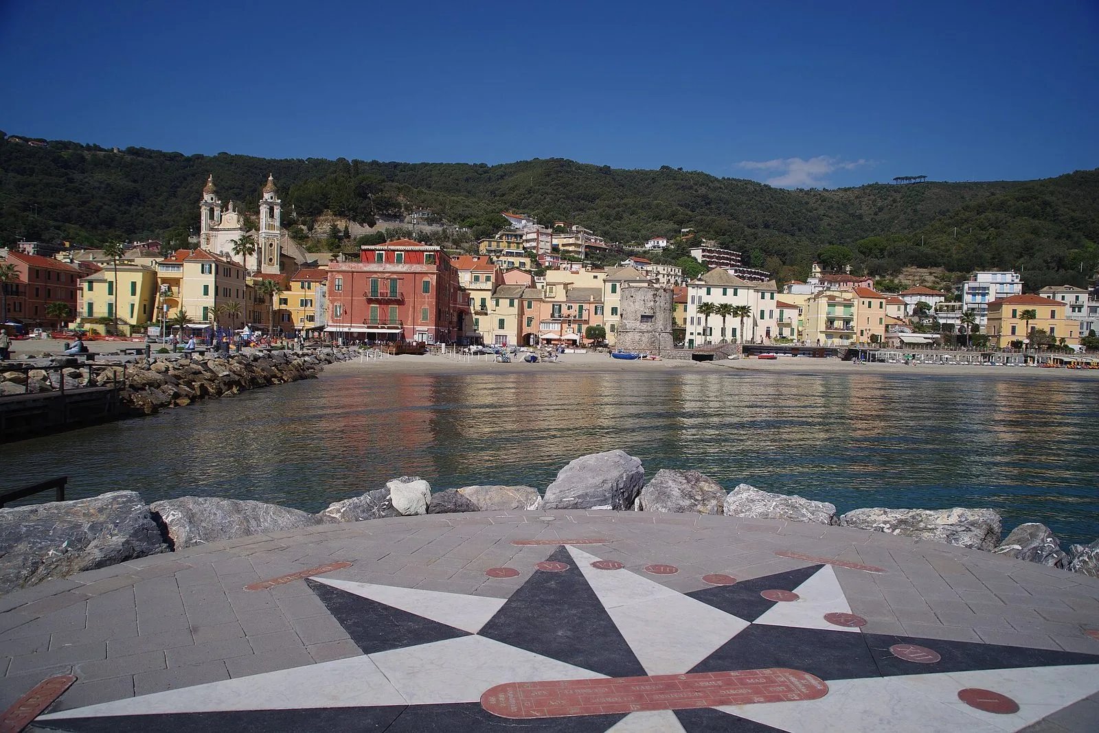 Laigueglia vista dal molo, con la spiaggia, la torre cinquecentesca e i campanili di San Matteo
